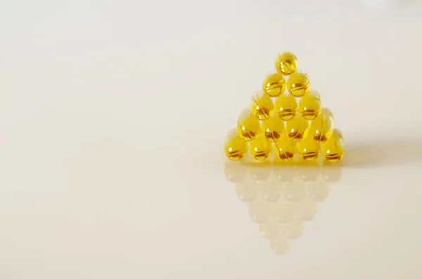 Pyramida ze žlutých průhledných tobolek. Omega 3 — Stock fotografie