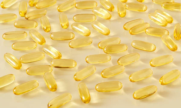 Una dispersión de transparente amarillo óvalo omega-3 cápsulas —  Fotos de Stock