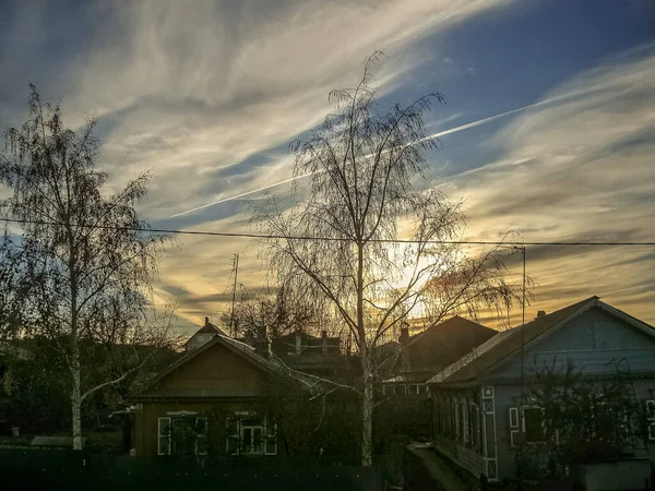 Сногсшибательное небо, и трек от реактивного самолета, деревенский пейзаж, дерево и домики — стоковое фото