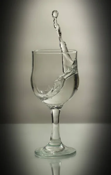 Stříkance rozptylující se ze sklenice na bílém izolovaném pozadí jako šplouchnutí šampaňského na dovolenou — Stock fotografie