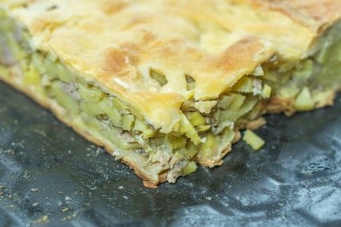 Bir parça fırında turta, patates ve dolma.