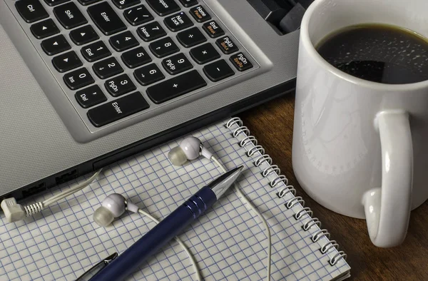 Laptop, pen, notebook, koptelefoon en kop koffie — Stockfoto