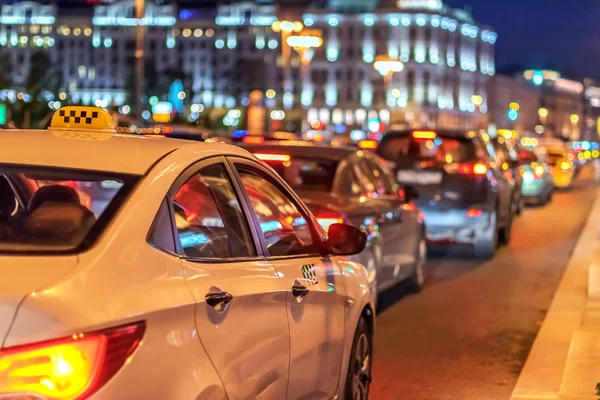 Taxi i trafikstockning på bakgrunden av lamporna i natten staden och bokeh — Stockfoto