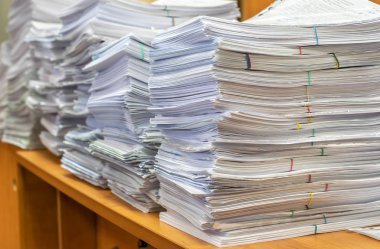 Bir tomar kağıt doküman. Paketler ofisteki masanın üzerine yığılır.