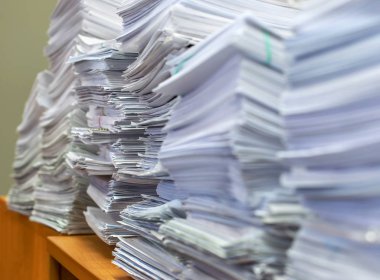 Bir tomar kağıt doküman. Paketler ofisteki masanın üzerine yığılır.