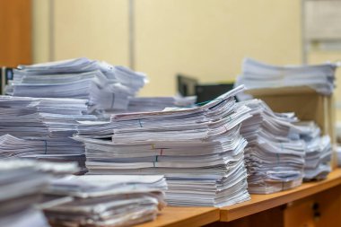 Bir tomar kağıt doküman. Paketler ofisteki masanın üzerine yığılır.
