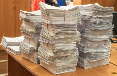 Bir tomar kağıt doküman. Paketler ofisteki masanın üzerine yığılır.