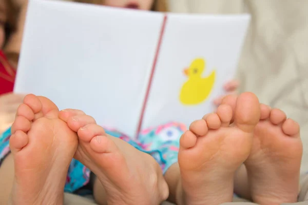 Barfußkinder lesen eine Geschichte Stockbild