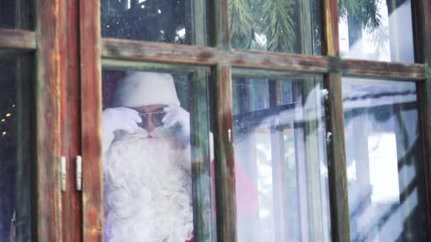 Санта Клаус Смотрит Окно Вид Снаружи Дом Санта Клаусом Очках — стоковое видео