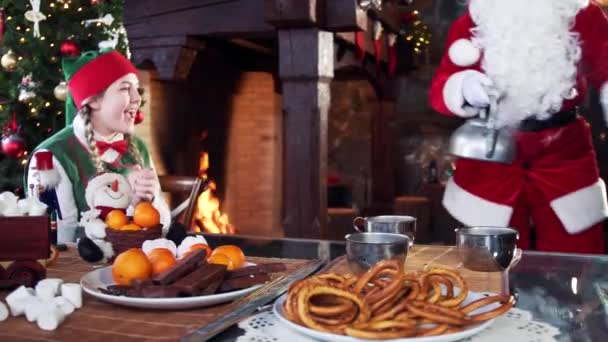 Elfo Fêmea Feliz Olhando Para Papai Noel Derramando Água Preparação — Vídeo de Stock