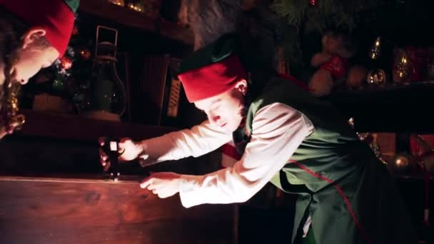 圣诞精灵在圣诞老人的房子里打开了一个闪闪发光的宝箱 — 图库视频影像