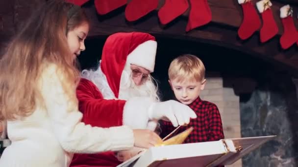 Boy Girl Reading Book Santa Claus Room Fireplace Christmas Stockings — Stock Video