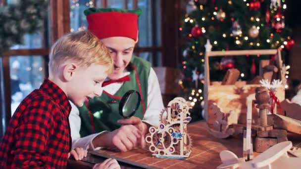 Elfo Papai Noel Está Brincando Com Menino Com Brinquedo Madeira — Vídeo de Stock