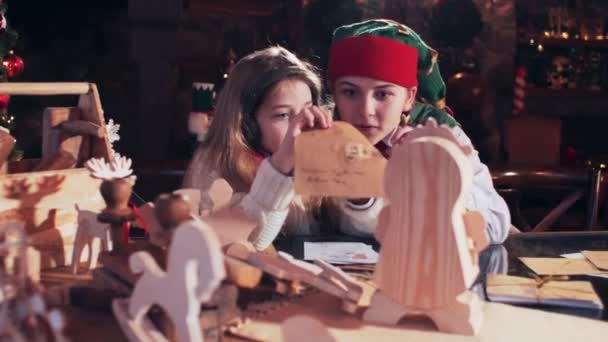 Санты Эльф Маленькая Девочка Рассматривают Письма Детям Комнате Рождественскими Игрушками — стоковое видео