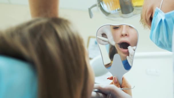 Uma Jovem Menina Olha Espelho Suas Mãos Como Dentista Trata — Vídeo de Stock