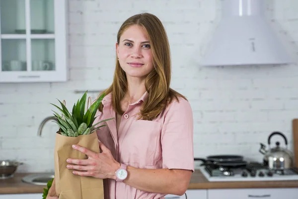 Tyttö keittiössä ekologinen paperipussi ostettua ruokaa . — kuvapankkivalokuva
