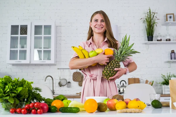 Kaunis nuori hymyilevä tyttö kädessään trooppisia hedelmiä . — kuvapankkivalokuva