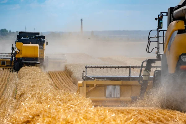 Gult kombinerer høsthvete. Jord med strå og støv fra kombinerte gressklippere. Sett bakfra . – stockfoto