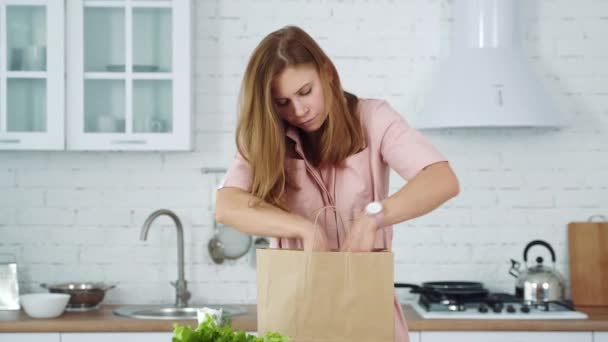 Chica Cocina Saca Una Naranja Una Manzana Una Bolsa Papel — Vídeo de stock