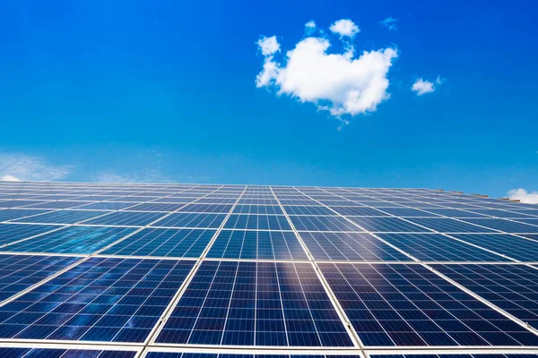 白い雲と青い空に対して電気を生成するための太陽電池パネル 代替エネルギー — ストック写真