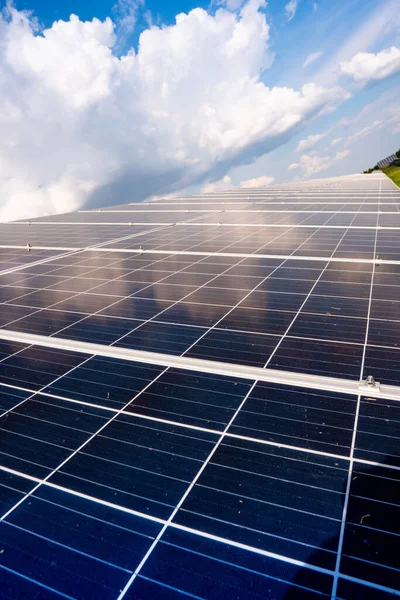 白い雲と空に対して発電所内の太陽電池パネルの行 再生可能エネルギー — ストック写真