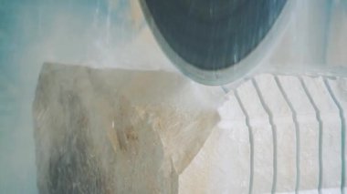 Dairesel testere büyük bir taşı küçük tabakalara ayırır. Fabrikada elektrikli testere ve su..