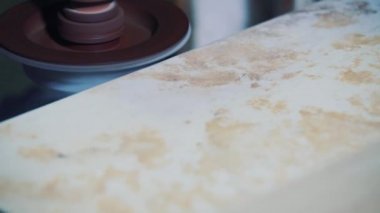 Cilalama makinesinin kumtaşı işlemleri. Fabrikada bir taş levhanın köşesinde..