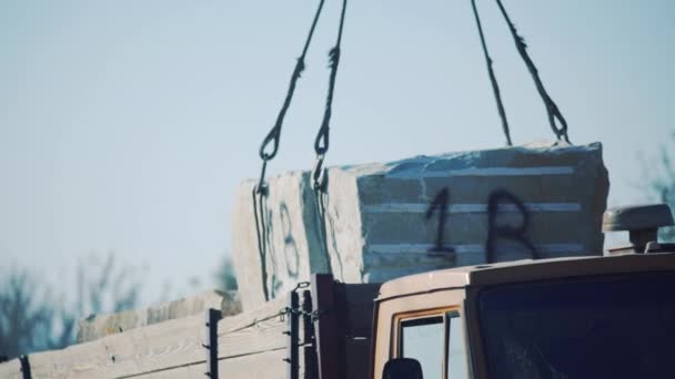 Ein Kran Hebt Einen Steinblock Von Einem Lkw Anhänger Sandstein — Stockvideo