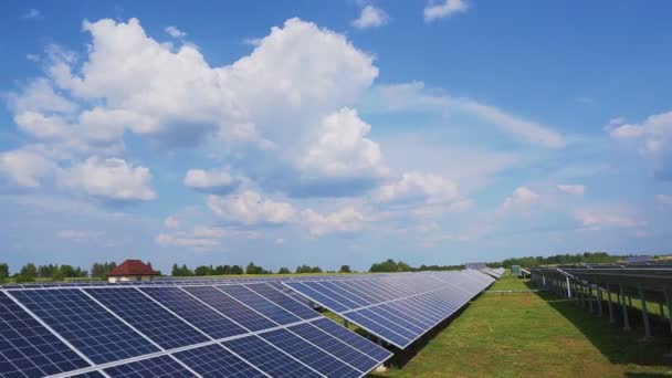 雲と空に対してフィールド内の太陽光発電所 青い太陽電池パネルの列 — ストック動画