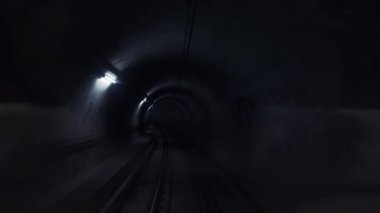 Duvarlarında fenerler olan karanlık metro tüneli. Modern şehir taşımacılığı.