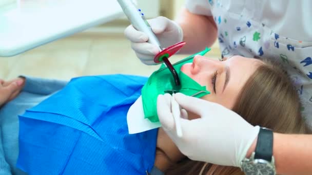 Tratamiento Relleno Diente Con Una Lámpara Fotopolímero Chica Del Dentista — Vídeos de Stock