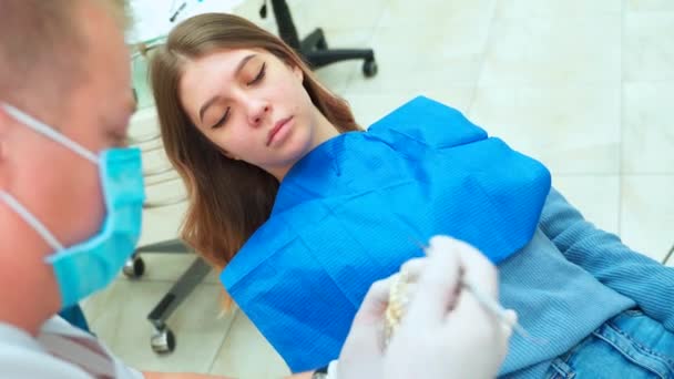 Menina Bonita Sorri Ouve Dentista Médico Mostra Layout Mandíbula — Vídeo de Stock