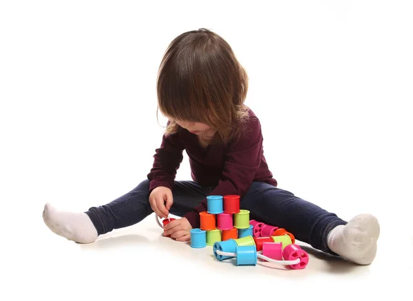 Niña de dos años jugando con carretes de algodón — Foto de Stock