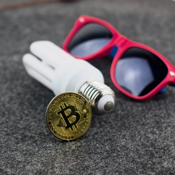 Bitcoin pièce d'or avec éco ampoule et lunettes roses — Photo