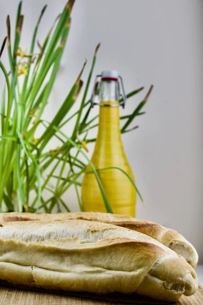 Fresh bread and yellow bottle — Stock Photo, Image