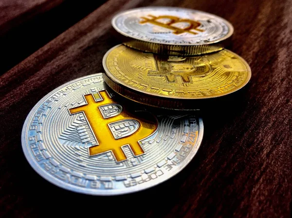 Tres monedas de bitcoin en la mesa de madera — Foto de Stock