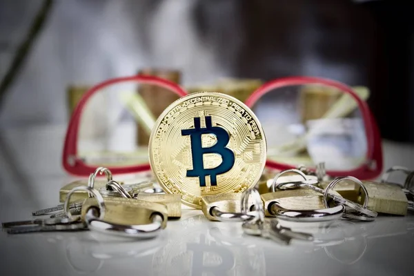Altın bitcoin sikke, asma kilitler ve gözlük