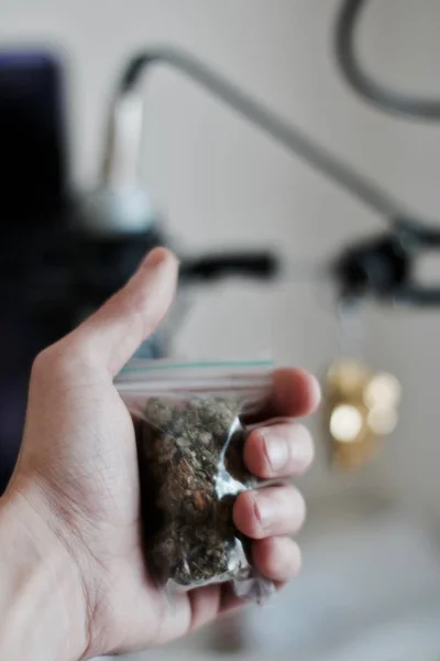 Bolsa con una marihuana en la mano — Foto de Stock