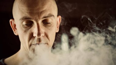 Kel genç adam vaping