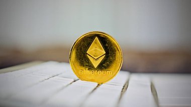 Dijital para fiziksel metal ethereum sikke üzerinde beyaz bilgisayar klavye.