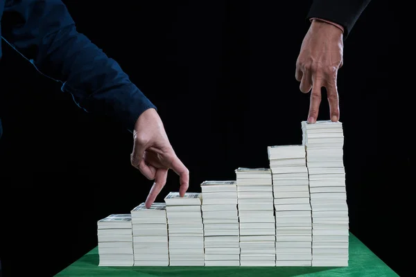 La acción de los dedos caminando sobre una pila de escaleras de billetes —  Fotos de Stock