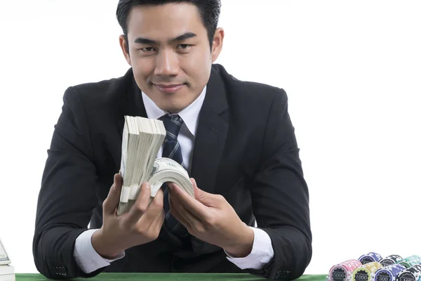 Portrait handsome man in black suit holding piles of dollars and — Stock Photo, Image