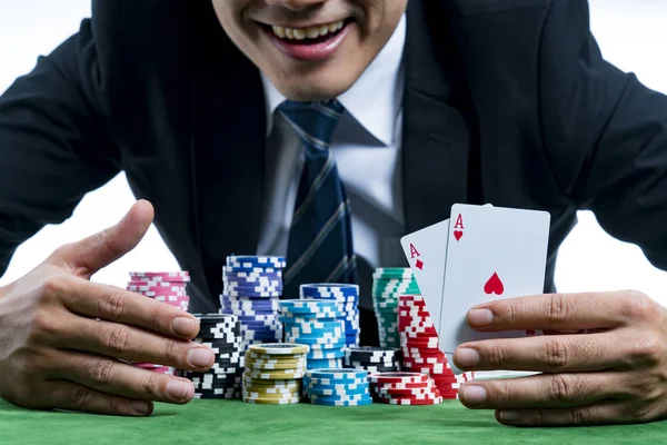 De poker speler vertoont een paar azen en glimlachend greep inzet — Stockfoto