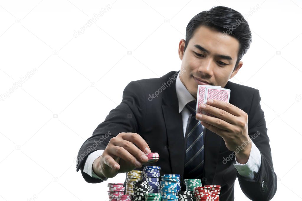 Portrait handsome man in black suit is putting piles of chips an