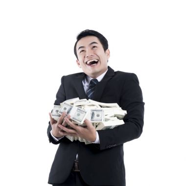 Genç adam gülüyor ve para büyük bir yığın tutarak