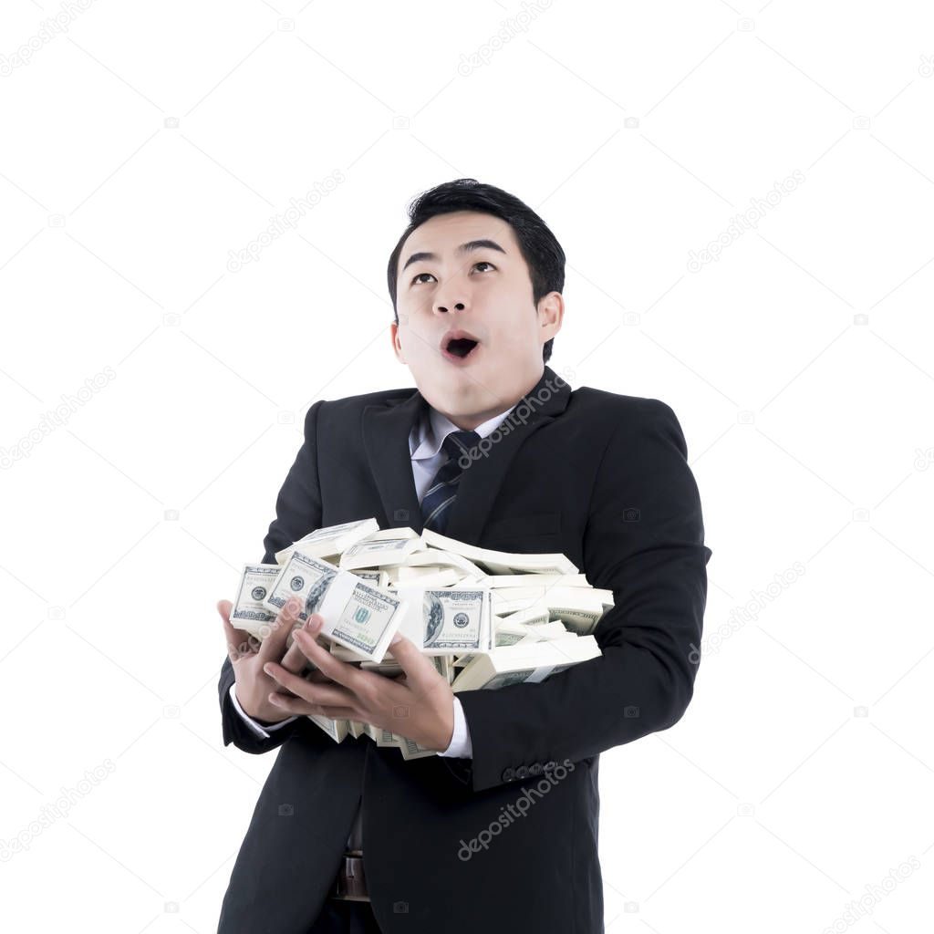 The cheerful young businessman holding a big pile of money in hi