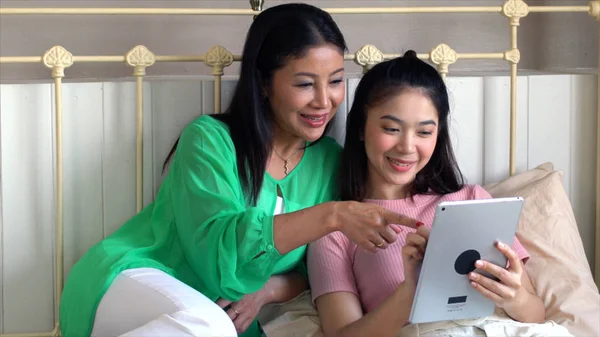 Mãe asiática com filha adolescente se divertindo com tablet no — Fotografia de Stock