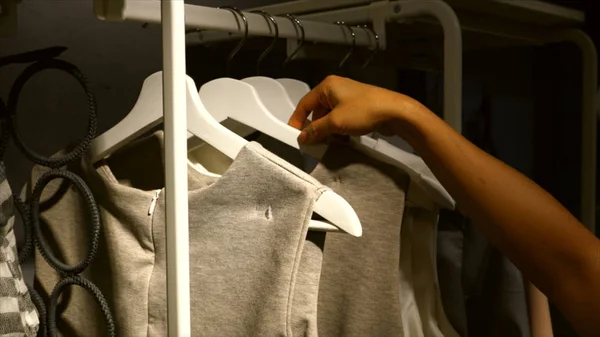 Woman choosing dress on a rack — Stockfoto