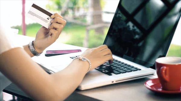 Achter van jonge vrouw te typen op de laptop en creditcard voor shopp — Stockfoto