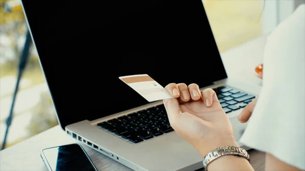 Achter van jonge vrouw te typen op de laptop en creditcard voor shopp — Stockfoto